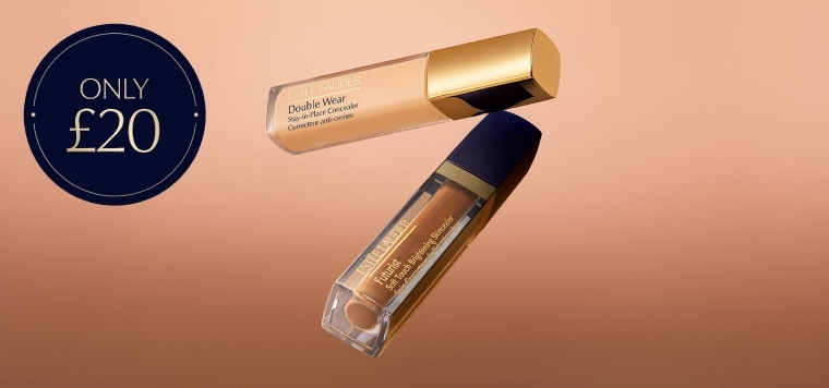 Two Estée Lauder concealers on a neutral background.