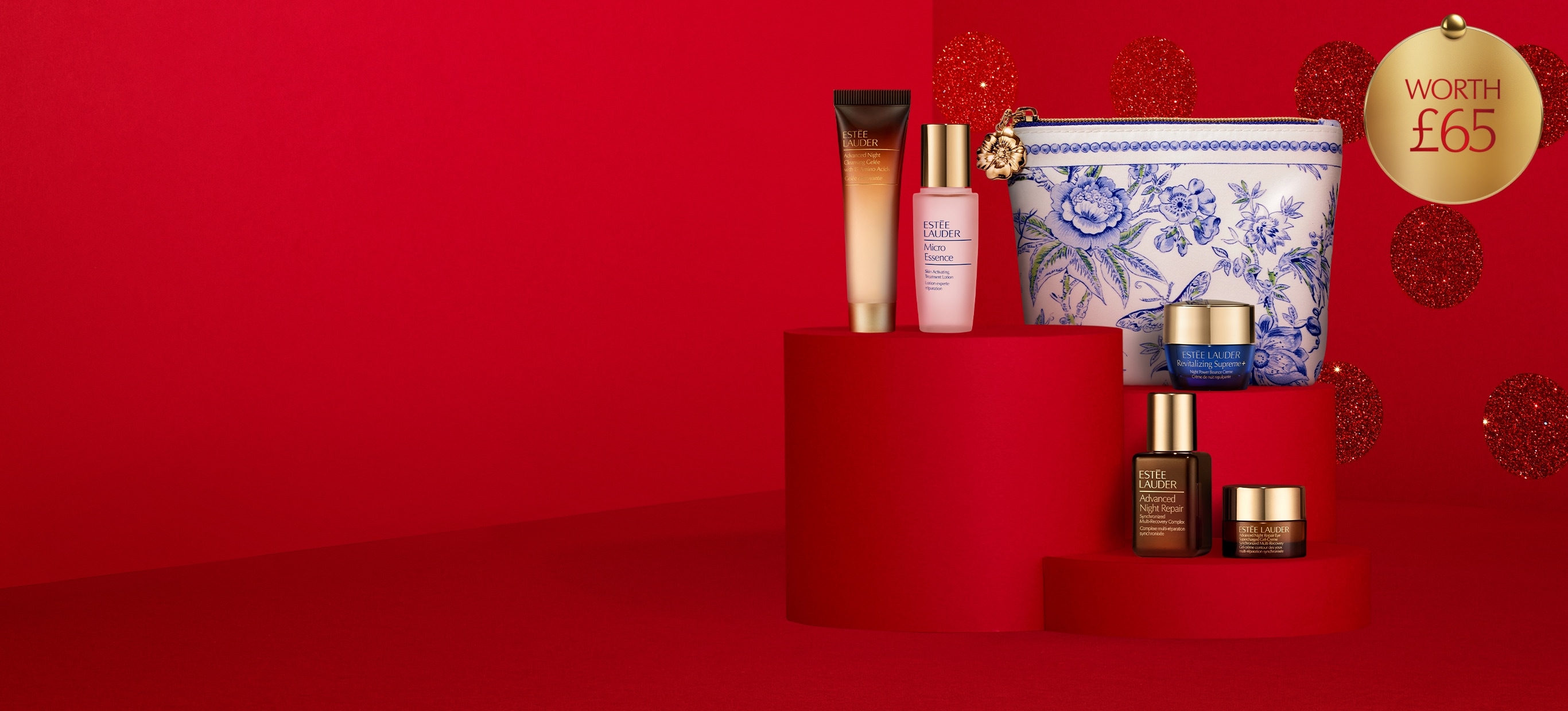 A selection of Estée Lauder products on a red polka dot background