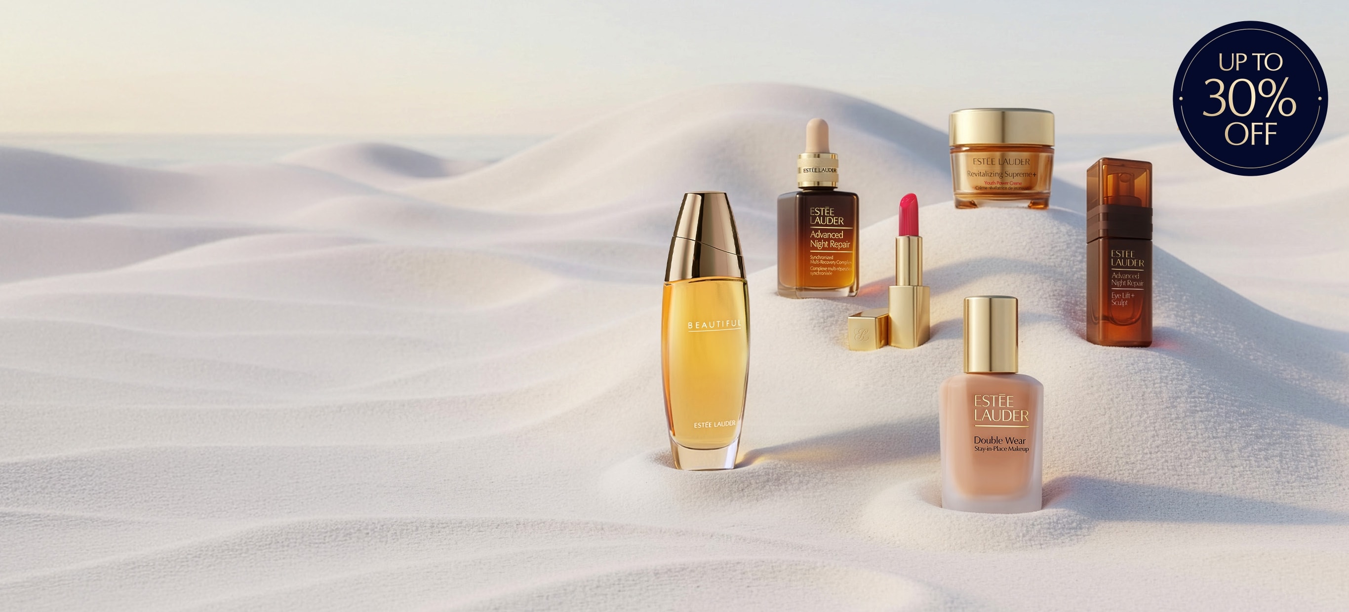 Estee Lauder products on a sandy background