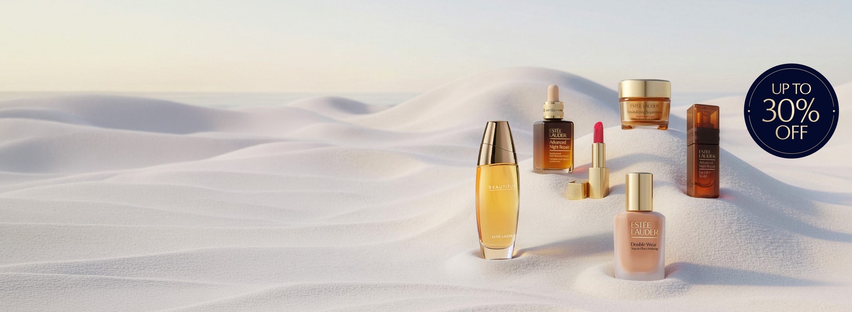 Estee Lauder products on a sandy background