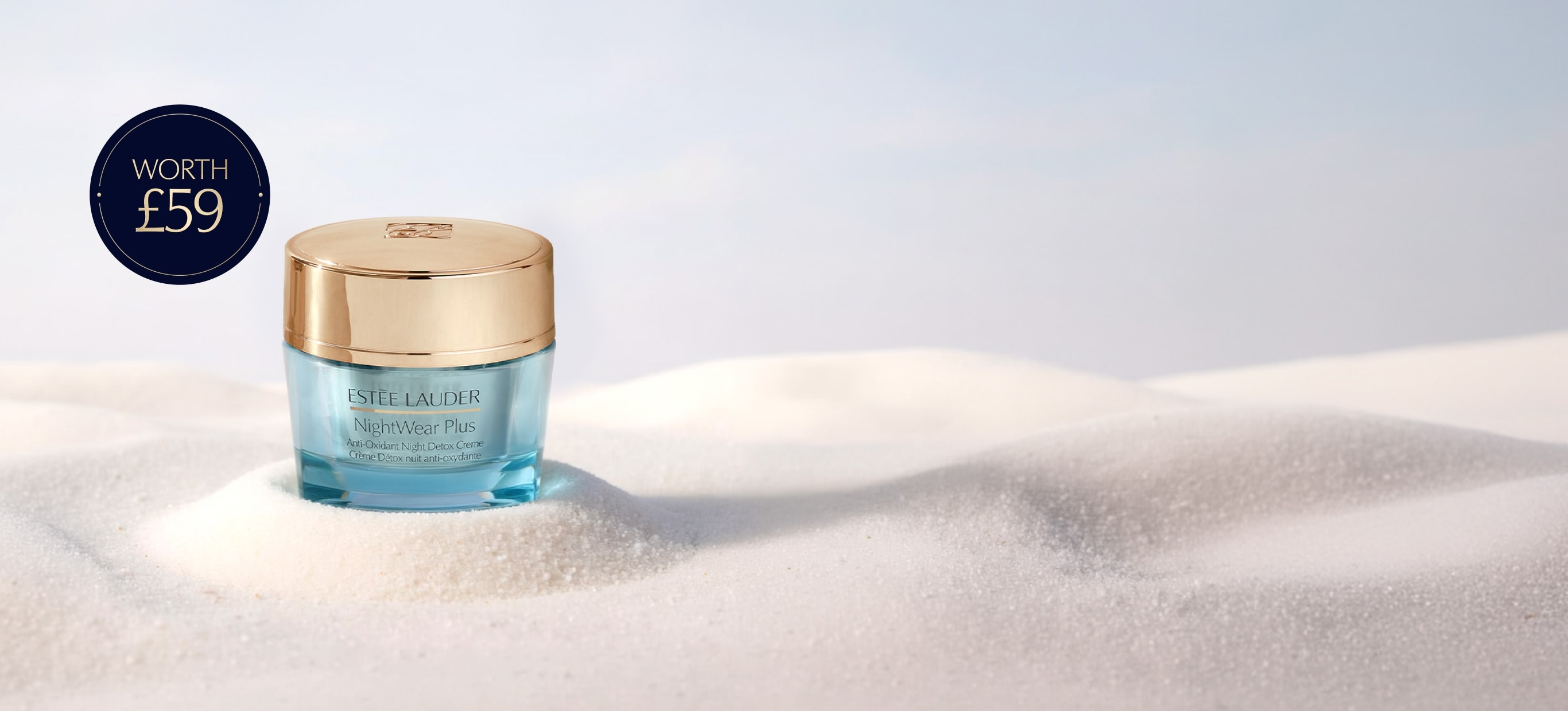 Estee Lauder products on a sandy background