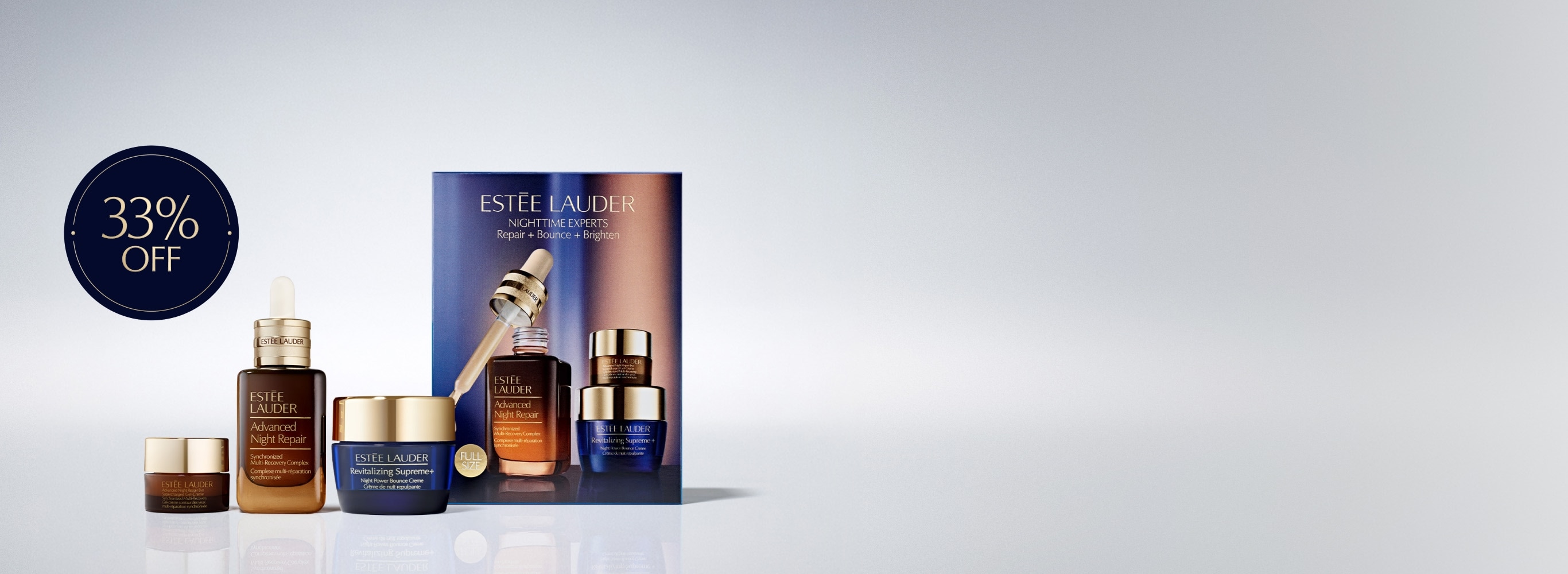 A selection of Estée Lauder products on a grey background.