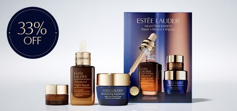 A selection of Estée Lauder products on a grey background.