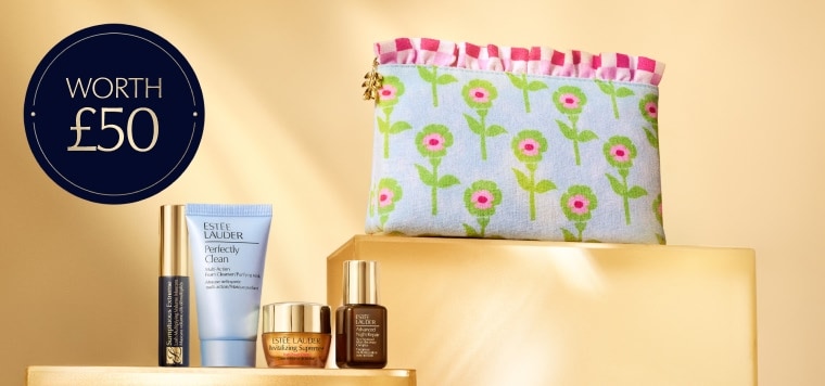 A selection of Estee Lauder products on an orange background