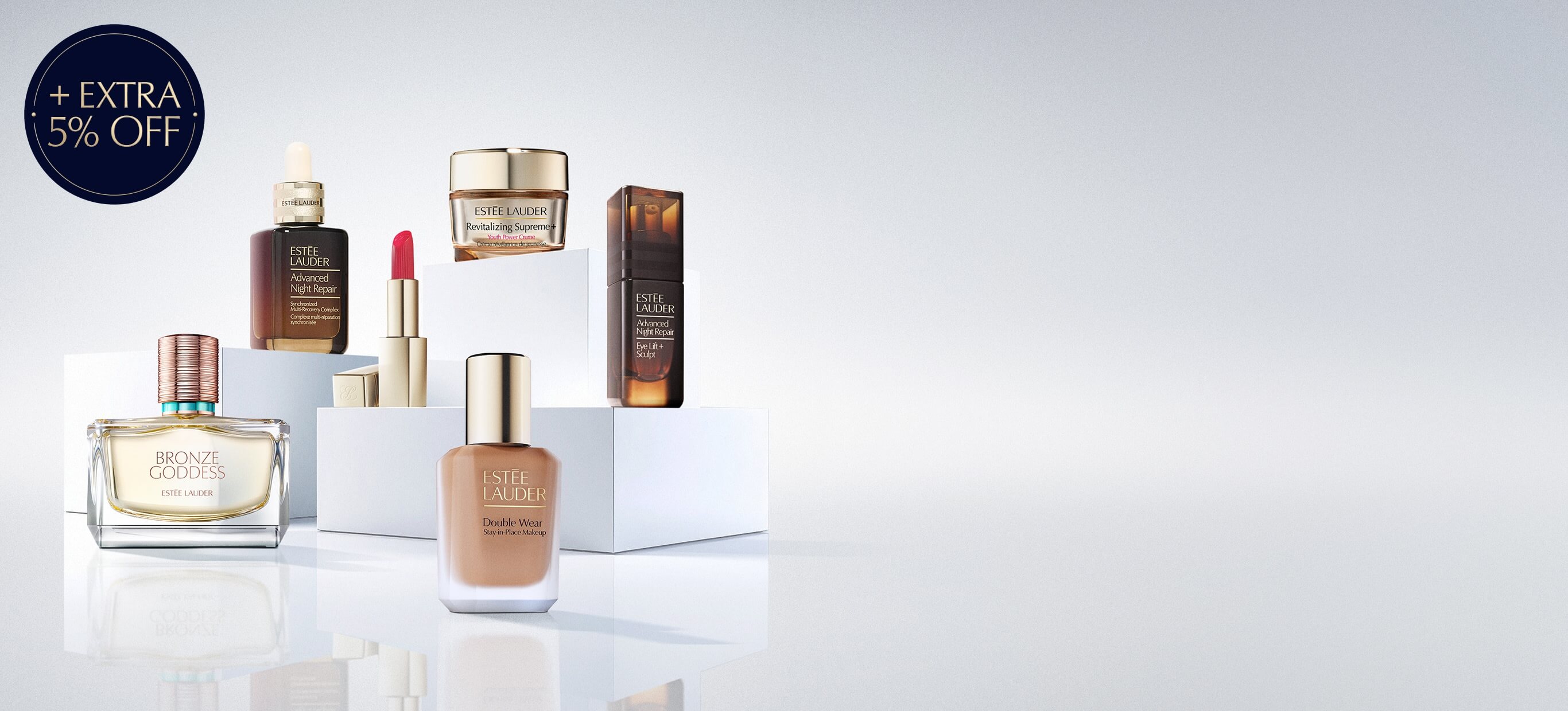 A selection of Estée Lauder products on a grey background.