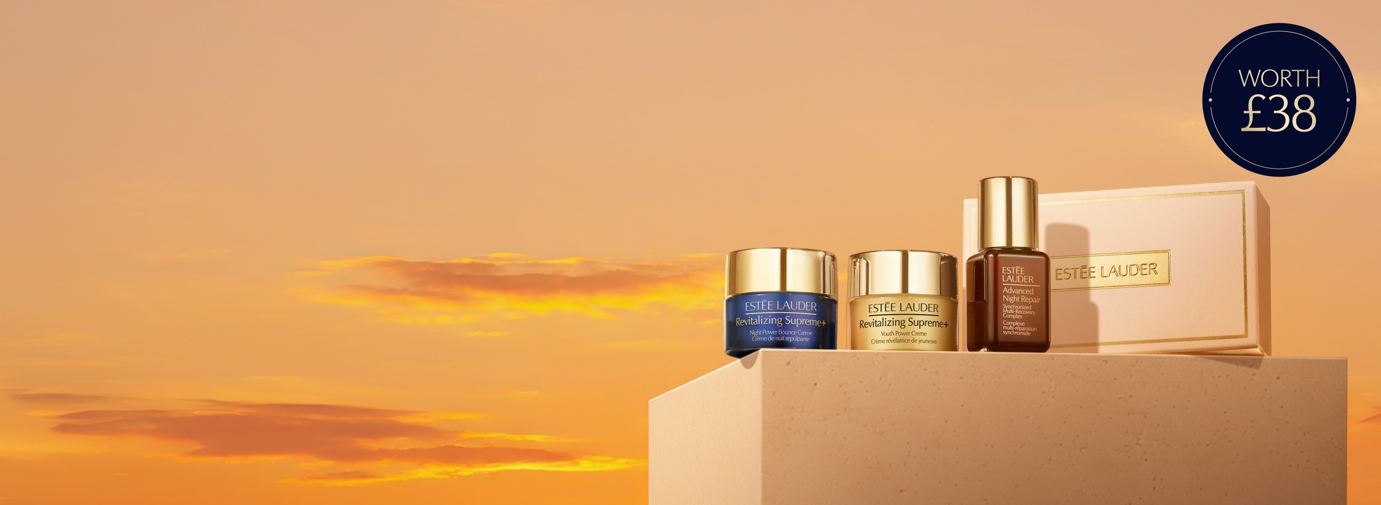 A selection of Estee Lauder products on a orange background