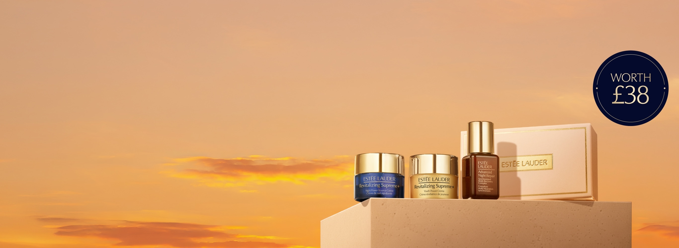 A selection of Estee Lauder products on a orange background