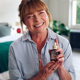 Janet Ellis holding a bottle of Advanced Night Repair Serum. 