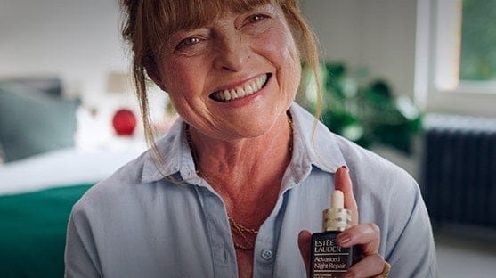 Janet Ellis holding a bottle of Advanced Night Repair Serum. 