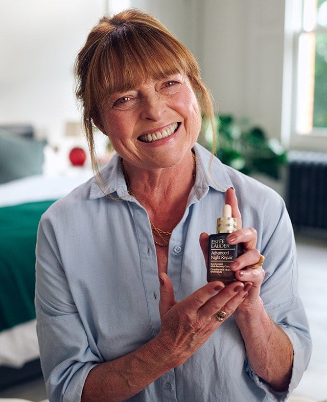 Janet Ellis holding a bottle of Advanced Night Repair Serum.