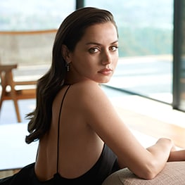 Ana de Armas looking to camera in a black dress