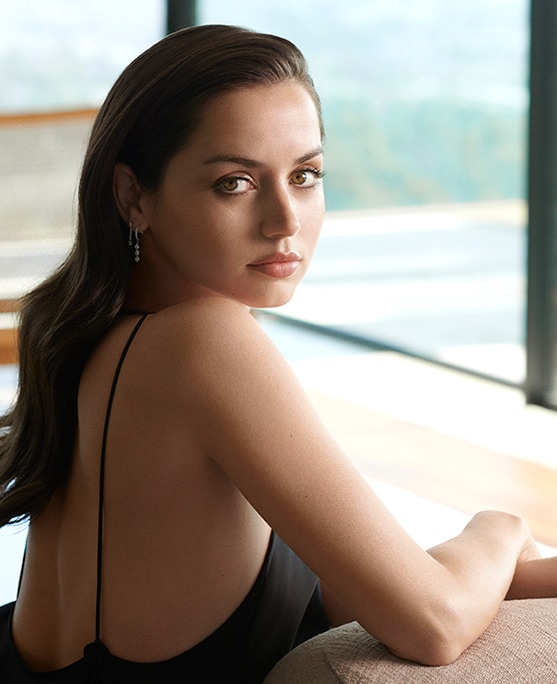 Ana de Armas looking to camera in a black dress
