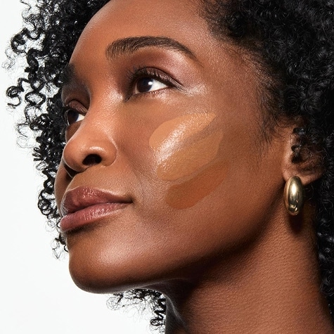 A mature woman with foundation swatches on her cheek