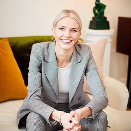 Georgiana Huddart in a grey suit, smiling to camera. 