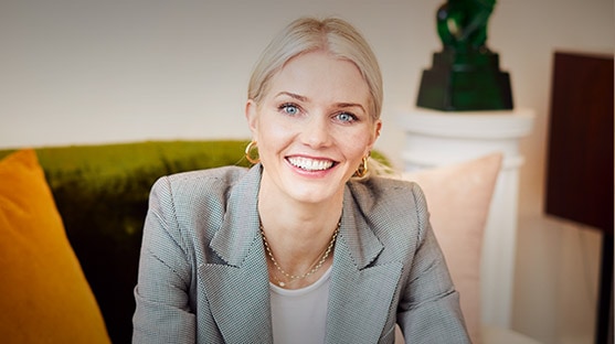 Georgiana Huddart in a grey suit, smiling to camera. 