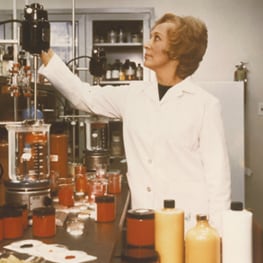 Mrs Estée Lauder in a lab coat at cosmetics factory. 