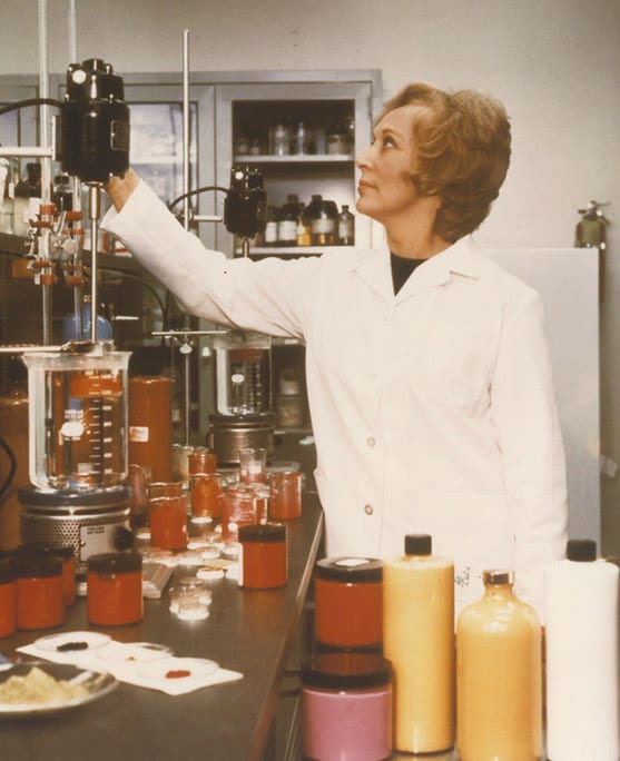 Mrs Estée Lauder in a lab coat at cosmetics factory. 