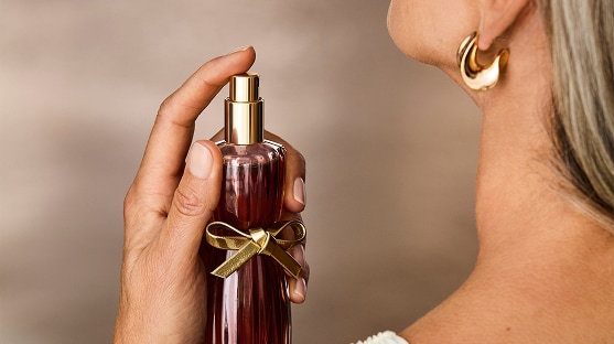 photo of woman applying long lasting fragrance from estee lauder