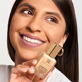 Pro Artist Kareen holds up a bottle of iconic Double Wear Makeup