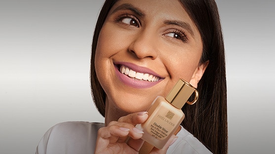 Pro Artist Kareen holds up a bottle of iconic Double Wear Makeup