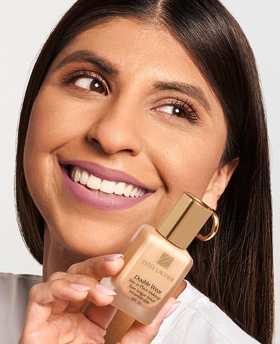 Pro Artist Kareen holds up a bottle of iconic Double Wear Makeup