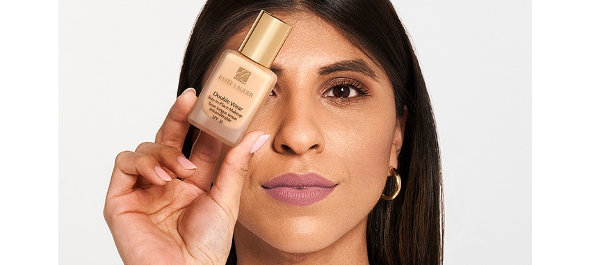 Pro Artist Kareen holds up a bottle of iconic Double Wear Makeup