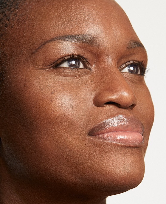 Woman with glowing skin looks into distance