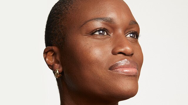 Woman with glowing skin stares into distance