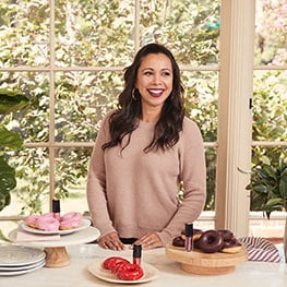 Recipe blogger Adriana Adarme of A Cozy Kitchen surrounded by sweet treats