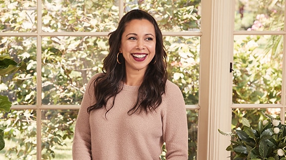 Recipe blogger Adriana Adarme of A Cozy Kitchen surrounded by sweet treats