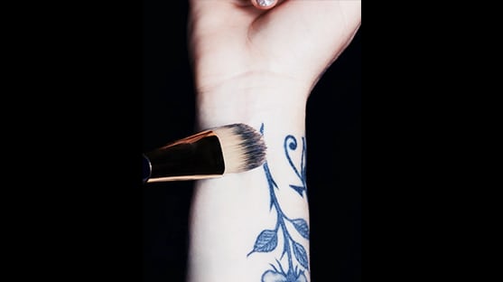 Double Wear Maximum Coverage Foundation for Face and Body SPF 15 being applied to a tattooed wrist, and the finished result of no tattoo visible once applied. 
