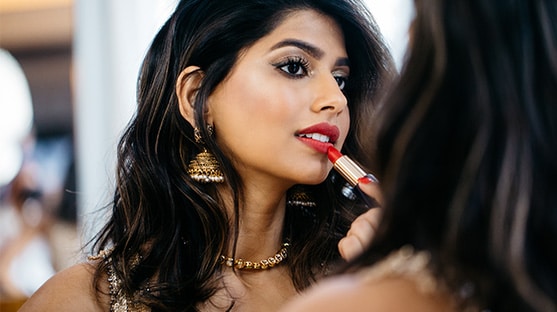 Beauty vlogger Arshia Moorjani applies makeup in the mirror