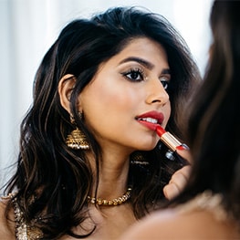 Beauty vlogger Arshia Moorjani applies makeup in the mirror