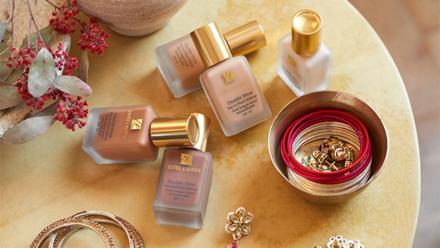 Double Wear Stay In Place Foundation lying on a table amongst jewellery