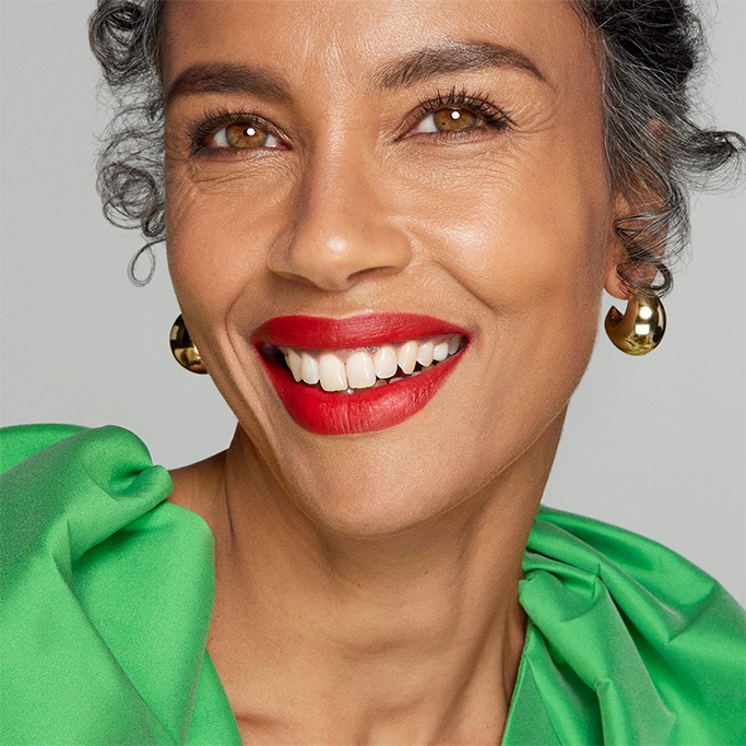 An image of a smiling lady with a bold red lipstick